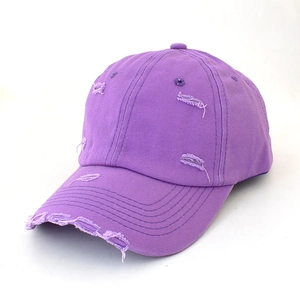 Detail of distressed purple cotton baseball cap with vintage worn holes and frayed edges