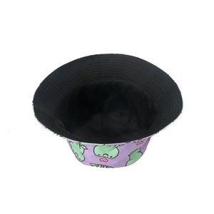 Detail of purple canvas bucket hat with cute green cartoon frog and heart pattern