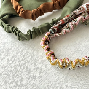 Detailed view of elastic fabric headbands in brown, green and colorful knitted patterns