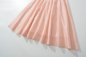 Detailed macro view of soft pink sleeveless dress with flowing pleated chiffon fabric texture