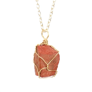 Detailed close-up of handmade wire-wrapped red jasper gemstone pendant with gold chain