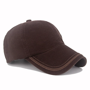 Detail view of reinforced stitching on the curved brim of a brown cotton baseball cap