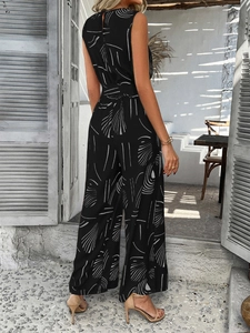 Detailed back view of a sleeveless black jumpsuit with abstract white patterns in sunlight