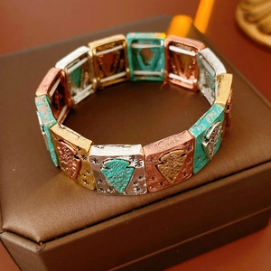 Close-up of vintage multi-color metal stretch bracelet with turquoise details on leather box