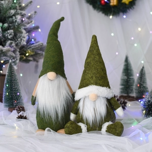 Detail von nordischen Weihnachtswichteln mit grünen Filzhüten und weißen Bärten in Festdeko
