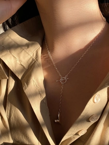 Lifestyle shot of an S925 silver heart necklace with OT toggle clasp on a stylish shirt