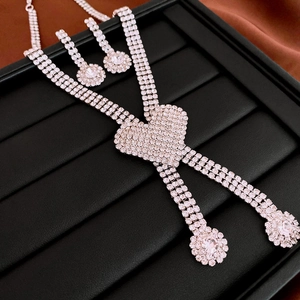 Close-up of silver heart pendant necklace and diamond earrings on black jewelry tray