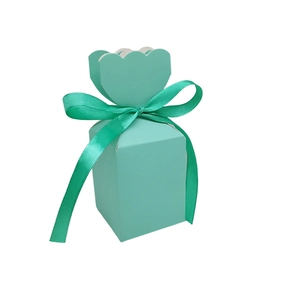 Detail of mint green gift box with petal-shaped top and matching silk ribbon bow
