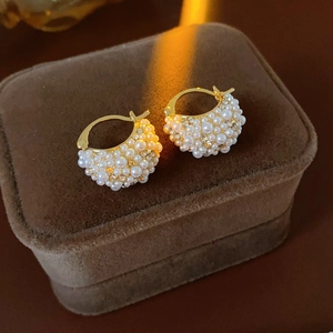 Detail of French style gold earrings with white pearls and rhinestones on velvet box