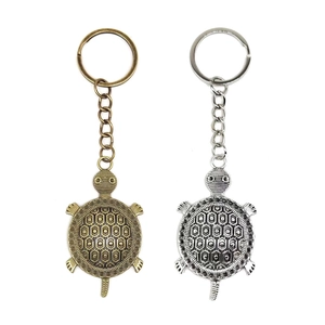 Vintage bronze and silver sea turtle keychains with hexagonal shell patterns on white background