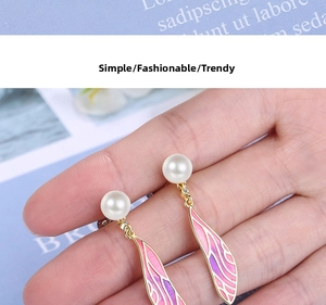 Close-up of pearl drop earrings with pink-purple gradient enamel wings and S925 silver studs