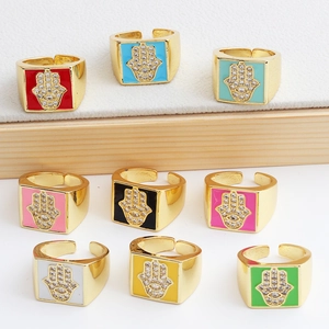 Detail of colorful enamel Hamsa hand rings with micro-set zircons on square bands