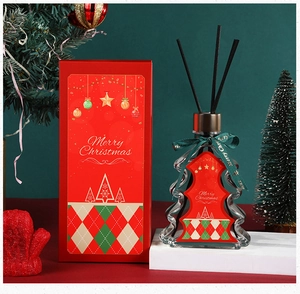 Detailed view of Christmas tree aroma diffuser set in festive red box with green ribbons