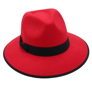 Detail of red wide brim fedora hat with black ribbon band on a white background