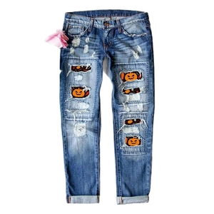 Blaue Jeans mit Halloween Kürbis-Patches und modischen Rissen im Denim-Stoff