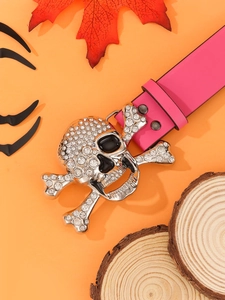 Pink punk belt with a silver skull buckle and sparkling rhinestones on orange background