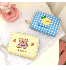 Detail of cute checkered card holders with cartoon lemon and bear prints and gold zippers