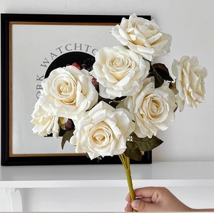 Detail of white artificial rose bouquet with realistic petals and green leaves