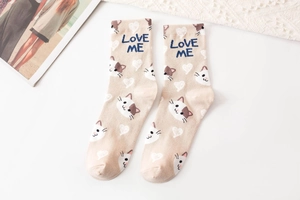Detail view of beige cotton crew socks featuring a calico cat pattern and Love Me text