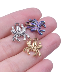 Detailed close-up of spider charms in silver, gold, and iridescent steel finishes