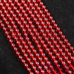 Macro shot of polished transparent red glass beads on a black velvet background