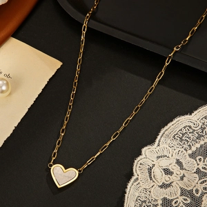 14K gold plated stainless steel heart necklace with paperclip chain on vintage background