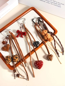 Detail of creative handmade bow and heart charms arranged on a wooden tray