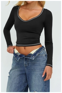 Dettaglio crop top nero aderente con bordo bianco a contrasto e scollatura a U