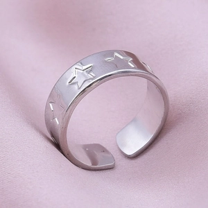 Vue macro d'une bague réglable en acier inoxydable argenté avec motifs d'étoiles