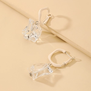 Detailed shot of irregular acrylic ice-cube drop earrings with cream-colored hoops