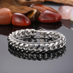 Detailed view of silver stainless steel Cuban link chain with lobster clasp on dark base