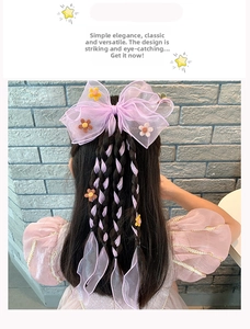 Detail of purple tulle bow hair clip with braided streamers and small floral accents