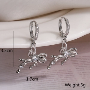 Detail shot of bow-shaped drop earrings with white zircons, size 3.3cm by 1.7cm