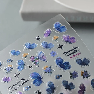 Macro shot of 3D embossed butterfly nail art stickers with blue and purple floral motifs