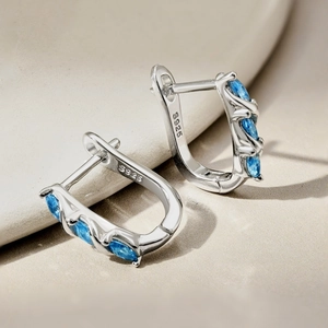 Macro shot of S925 sterling silver hoop earrings with marquise-cut blue zircon stones