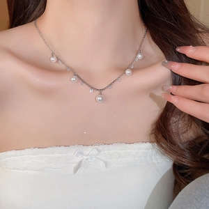 Detailed close-up of pearl tassel necklace with silver chain and tiny sparkling diamonds