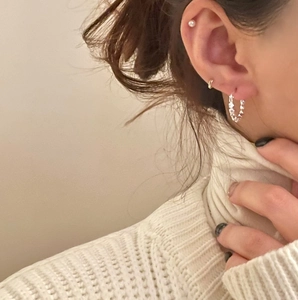 Close-up of minimalist S925 silver earring set with pearl stud and metal textured hoops