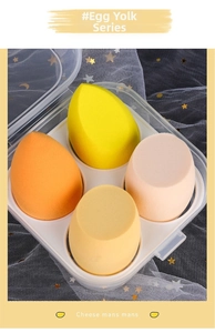 Detail of four yellow makeup sponges in a clear storage box with multiple shapes