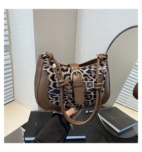 Close-up of leopard print shoulder bag featuring a knotted handle and leather buckle detail