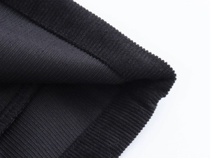 Vista macro della trama del velluto a coste nero e dettagli di cucitura per pantaloncini