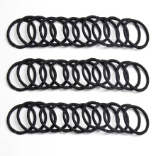 Detailed view of heavy-duty black elastic hair ties set in a neat bulk arrangement