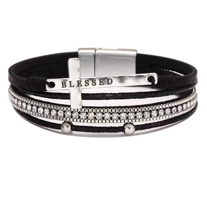 Detail of bohemian black leather bracelet featuring silver cross and rhinestone inlay