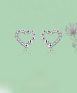 Detail of S925 silver heart stud earrings with cubic zirconia and polished beads