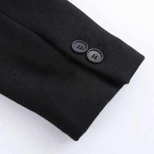Detail of black coat sleeve showing twill fabric texture and two four-hole buttons