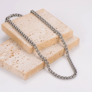Polished silver stainless steel dragon bone chain necklace for men on stone display