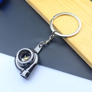 Macro view of a polished silver metal car turbocharger keychain with detailed turbine structure