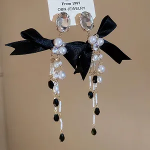 Elegant silver bow earrings with pearl tassels and crystal studs for a vintage look