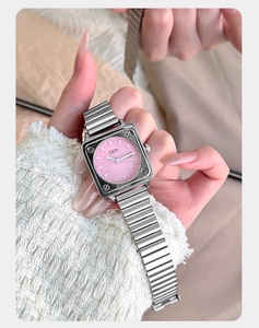 Dettaglio di un orologio al quarzo quadrato argento con quadrante rosa.