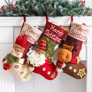 Three large Christmas stockings with 3D Santa, snowman, and reindeer on a white fireplace