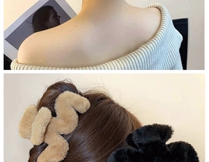 Detail of 14cm plush hair claw clips in brown and black on a textured wave design
